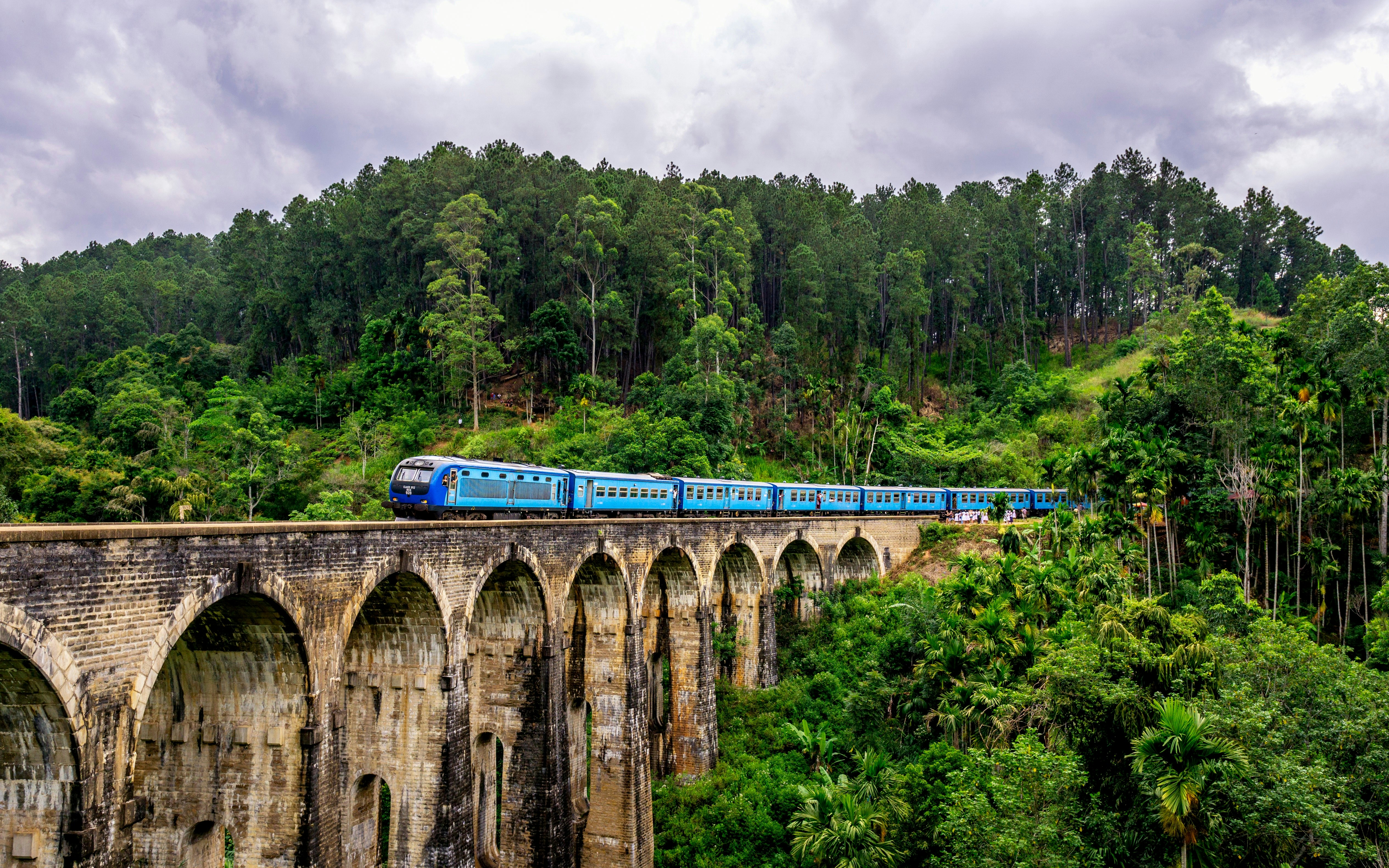 Sri Lanka's iconic blue train crossing the Nine Arch Bridge through tea country near Ella